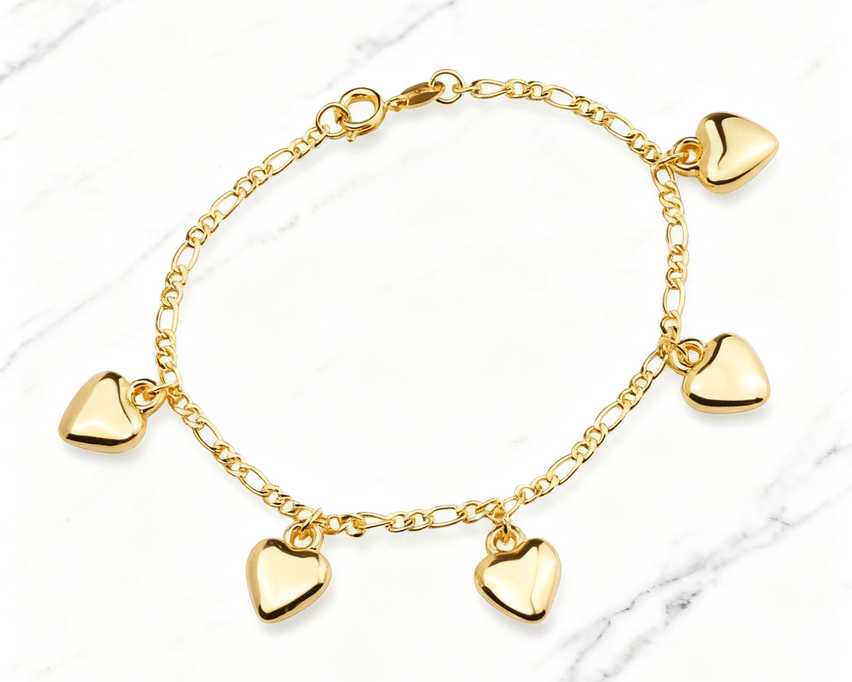 Pulseira Dourada com Pingentes de Coração Auvane em fundo de mármore claro com veios elegantes