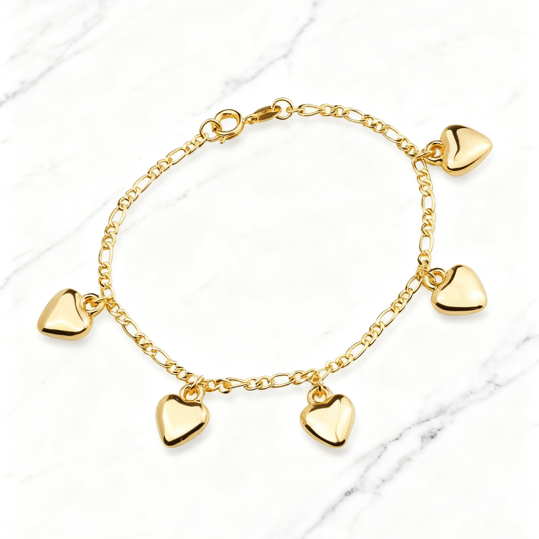 Pulseira Dourada com Pingentes de Coração Auvane em fundo de mármore claro com veios elegantes
