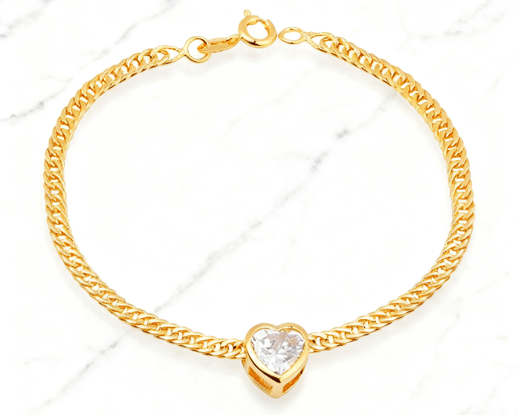 Pulseira Dourada Coração com Zircônia Auvane em fundo de mármore claro com veios elegantes