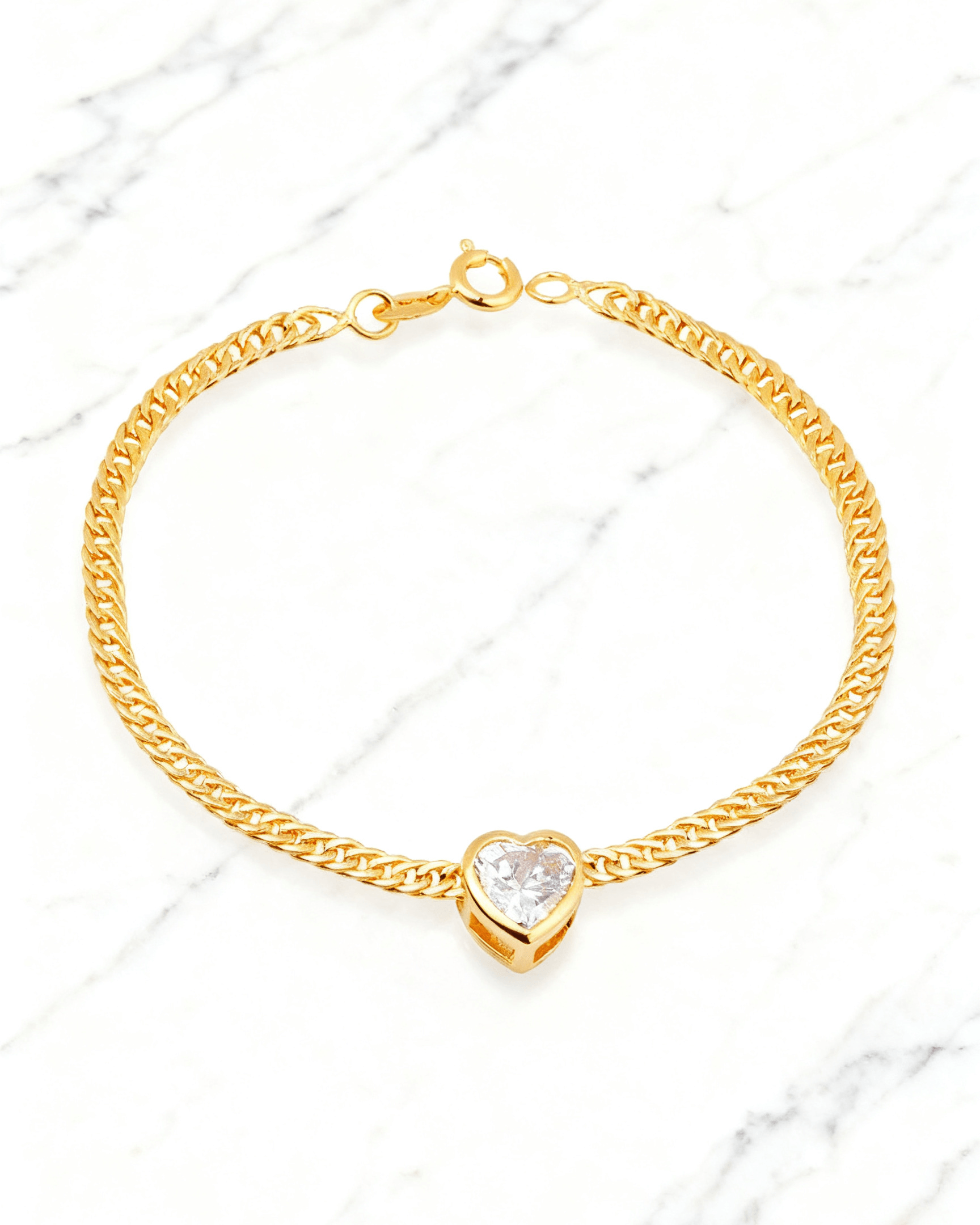 Pulseira Dourada Coração com Zircônia Auvane em fundo de mármore claro com veios elegantes