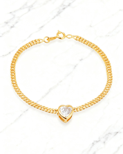 Pulseira Dourada Coração com Zircônia Auvane em fundo de mármore claro com veios elegantes