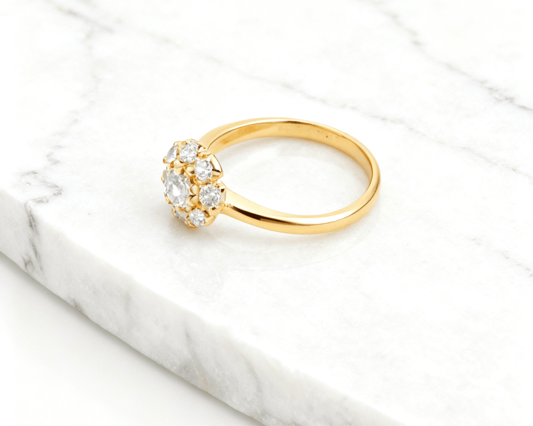 Anel Dourado com 9 Zircônias Auvane em fundo de mármore claro com veios elegantes