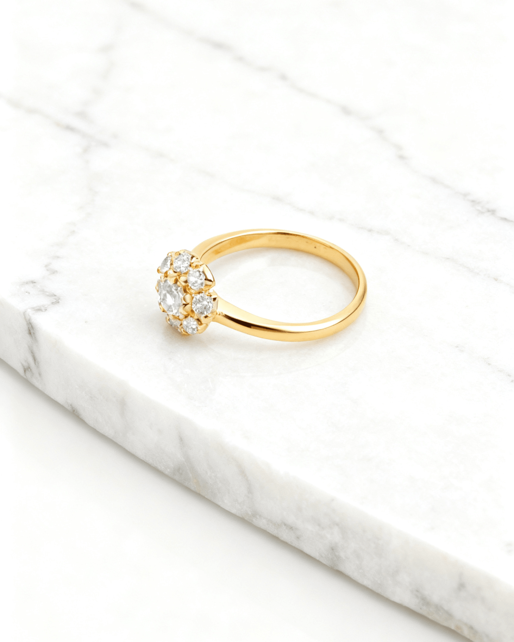 Anel Dourado com 9 Zircônias Auvane em fundo de mármore claro com veios elegantes