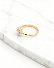 Anel Dourado com 9 Zircônias Auvane em fundo de mármore claro com veios elegantes