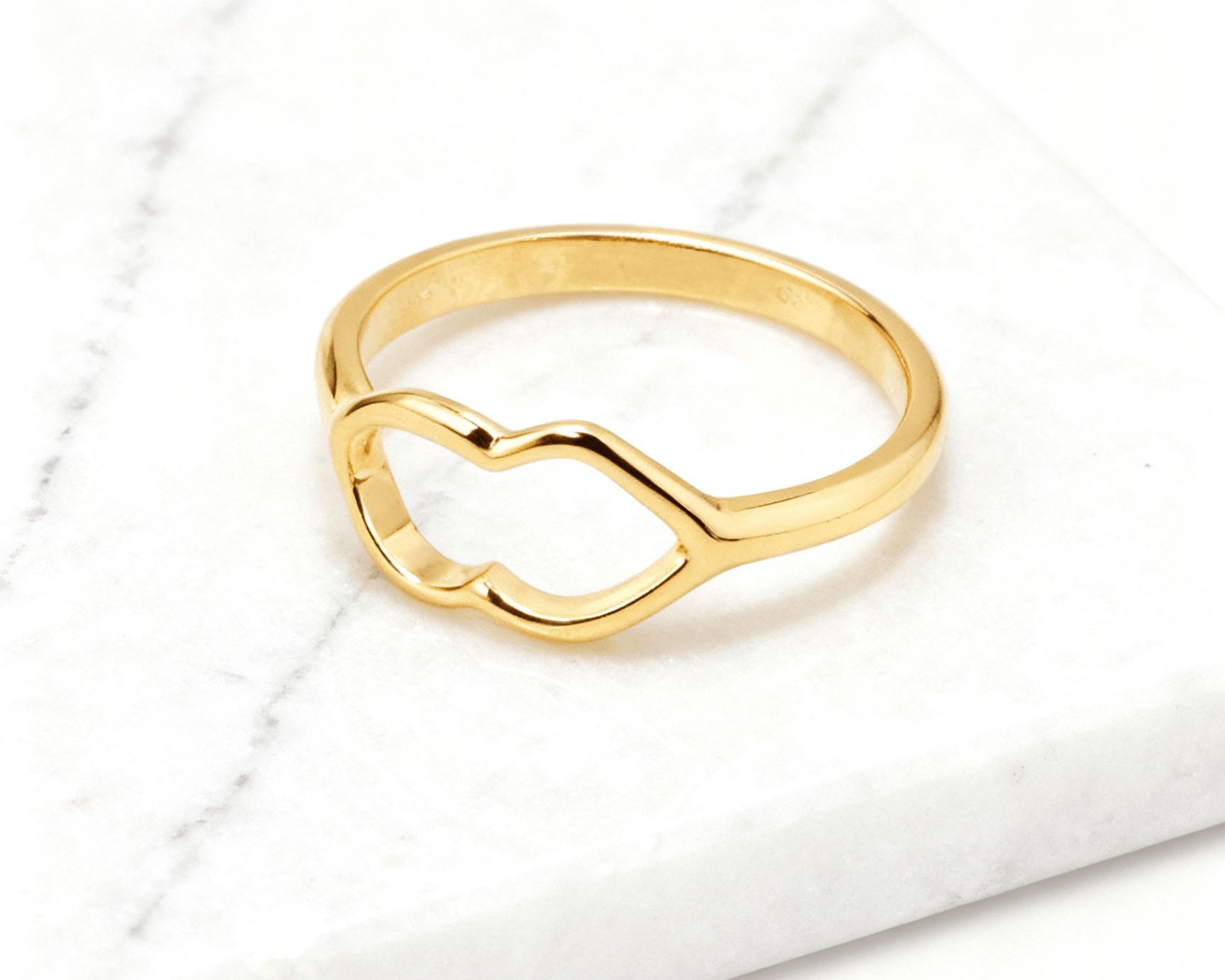 Anel Dourado de Coração Delicado Auvane em fundo de mármore claro com veios elegantes