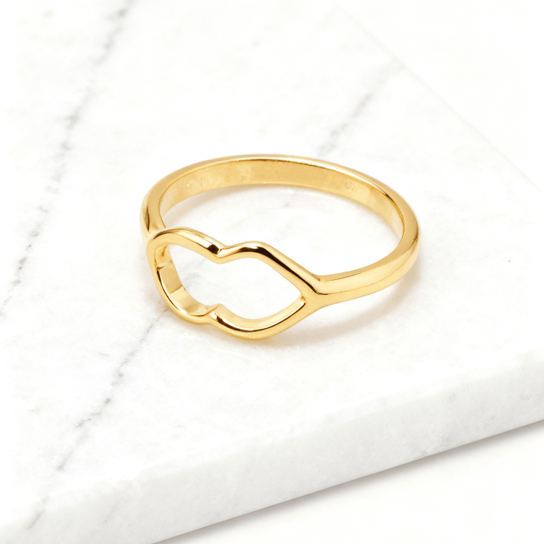 Anel Dourado de Coração Delicado Auvane em fundo de mármore claro com veios elegantes