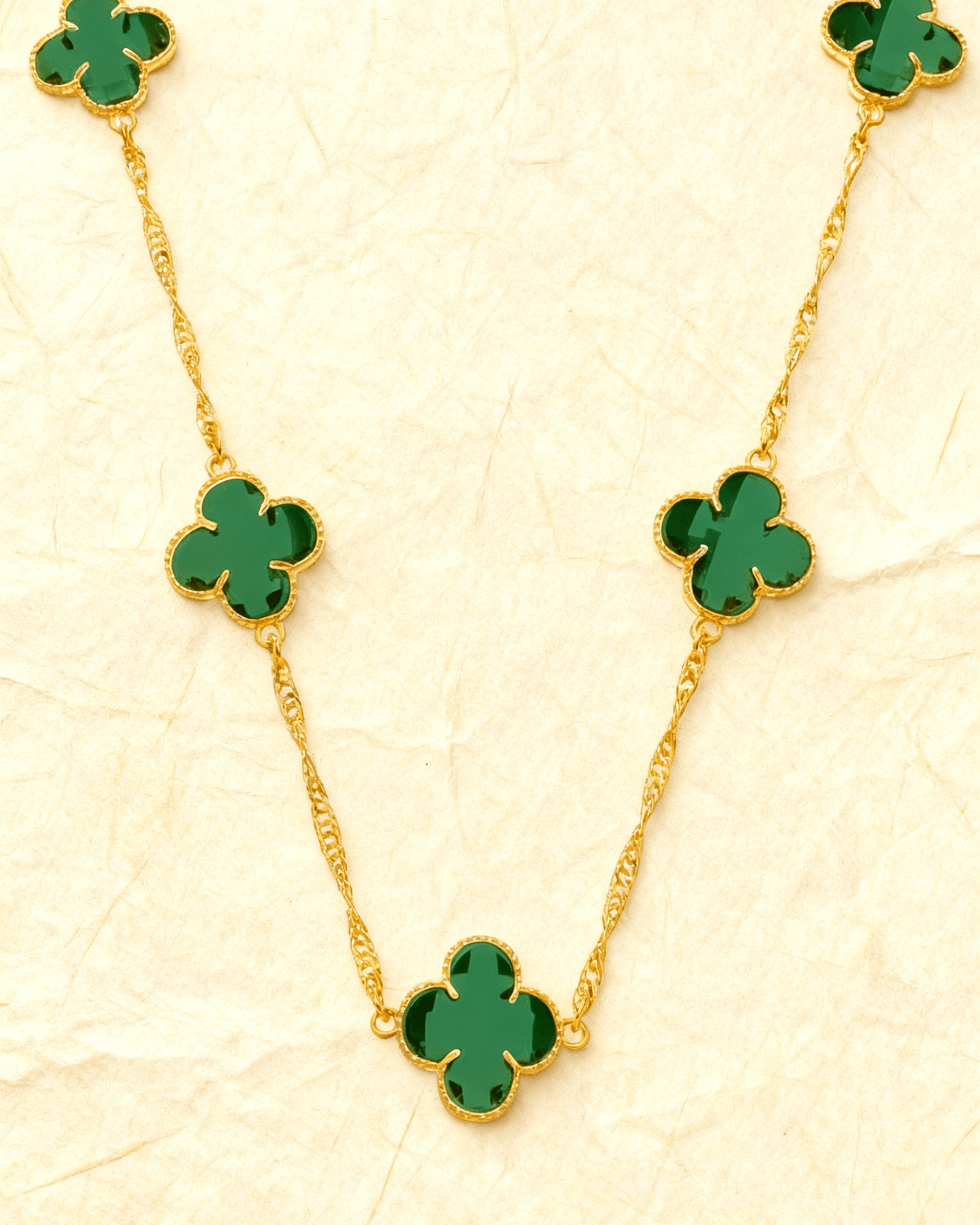 Colar Dourado 5 Trevos Verde Auvane sobre papel artesanal cream