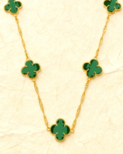 Colar Dourado 5 Trevos Verde Auvane sobre papel artesanal cream