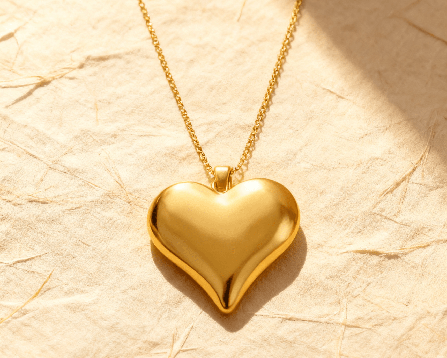 Colar Dourado de Coração Liso Auvane sobre papel artesanal cream