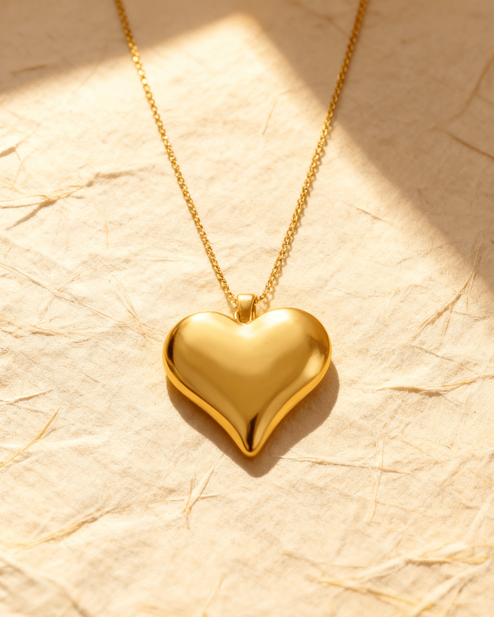Colar Dourado de Coração Liso Auvane sobre papel artesanal cream
