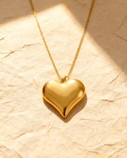 Colar Dourado de Coração Liso Auvane sobre papel artesanal cream