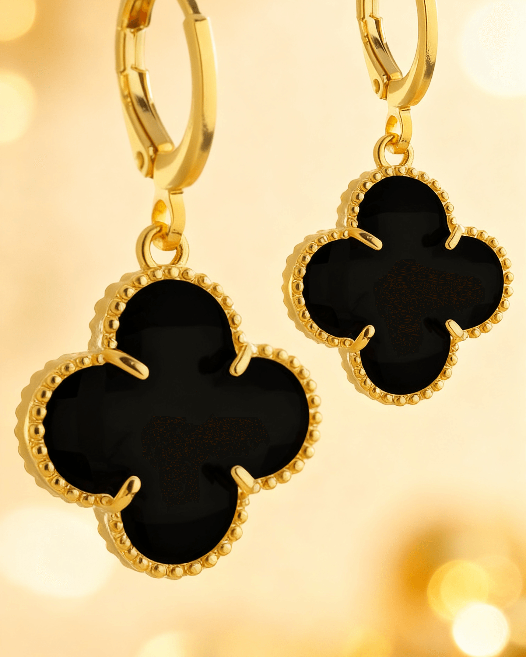 Detalhe macro do Brinco Trevo Dourado com Zircônia Preta Auvane com brilho do dourado
