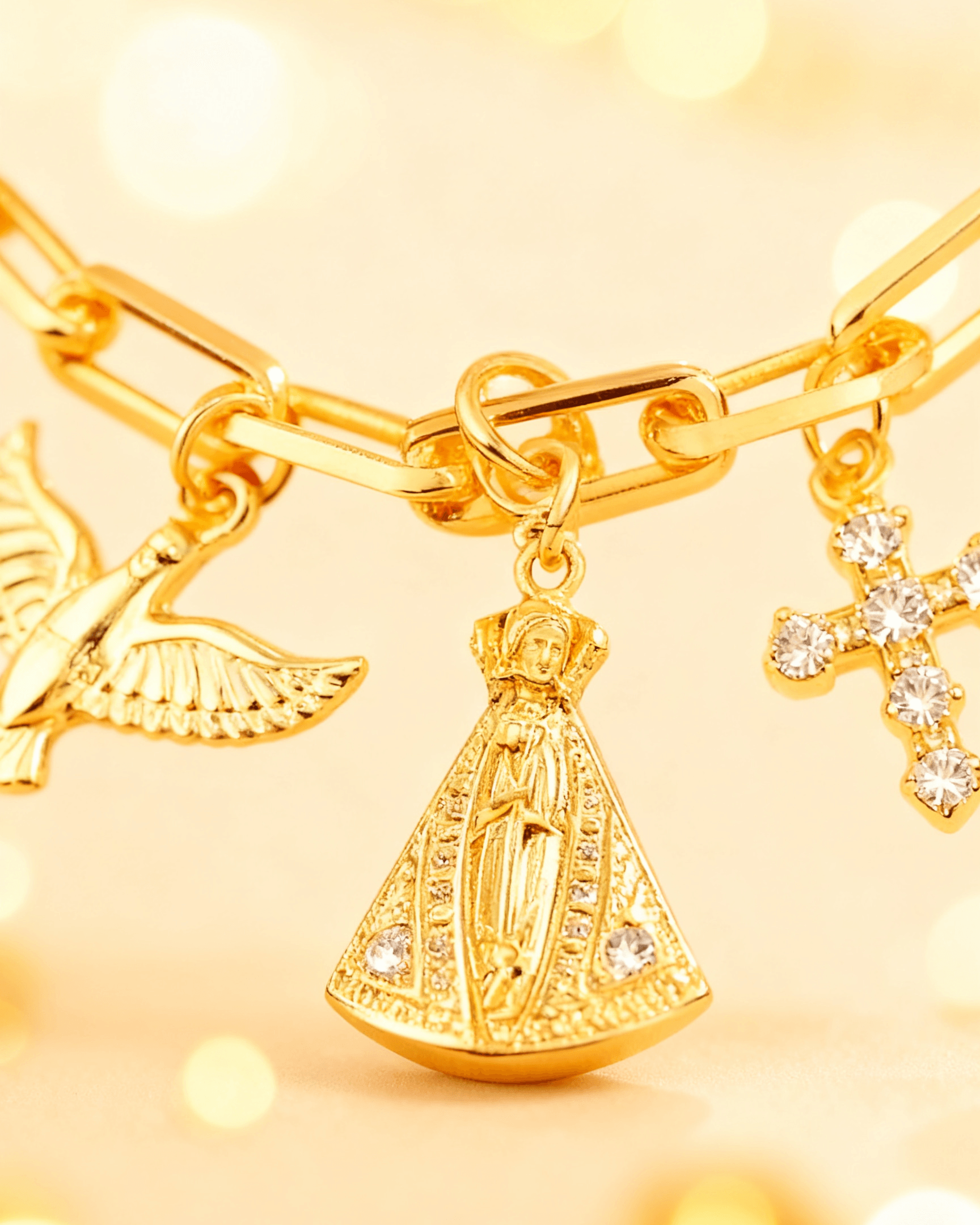 Detalhe macro do Pulseira Dourada Religiosa Nossa Senhora, Espírito Santo e Cruz Auvane com brilho do dourado