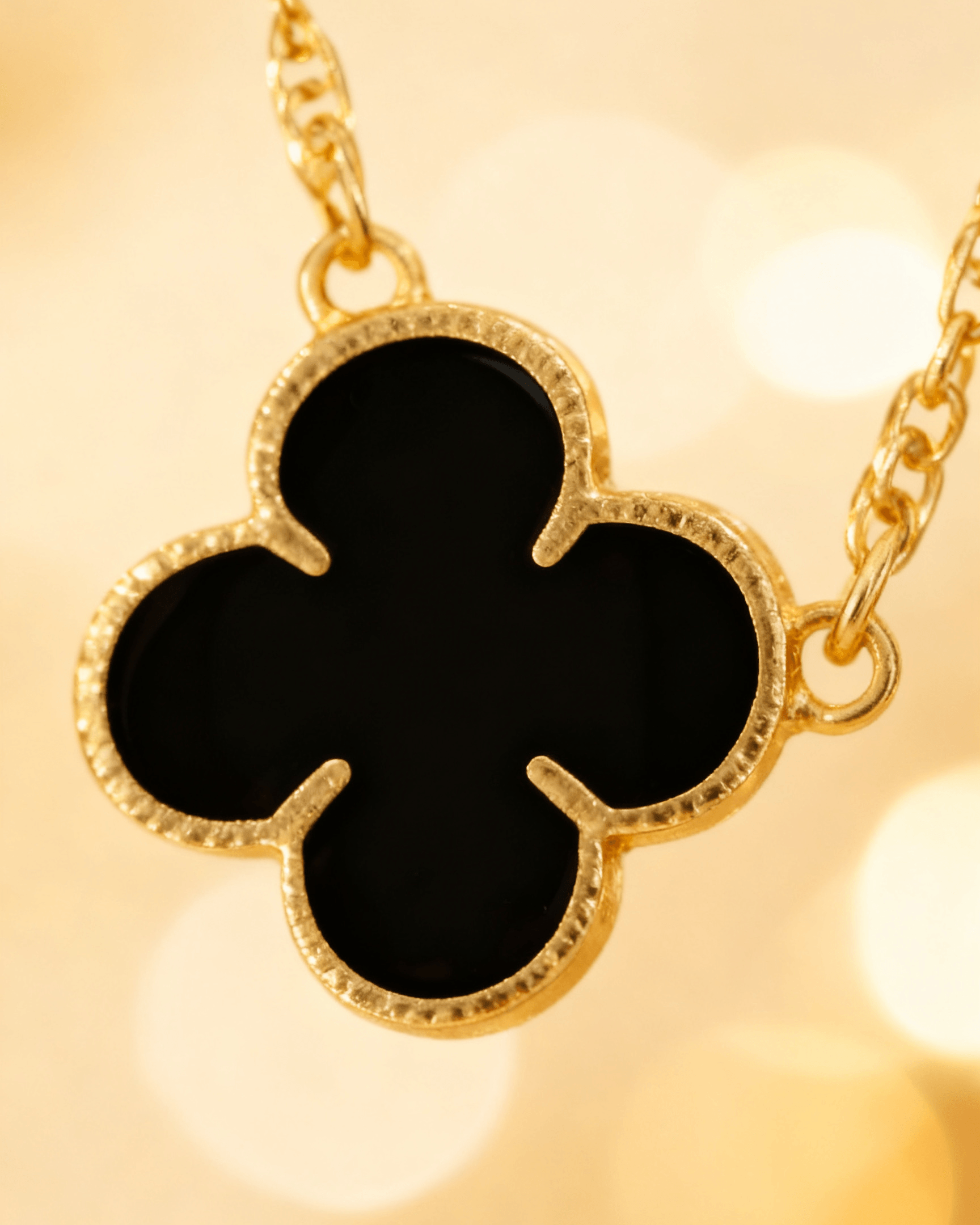 Detalhe macro do Colar Dourado 5 Trevos Preto Auvane com brilho do dourado