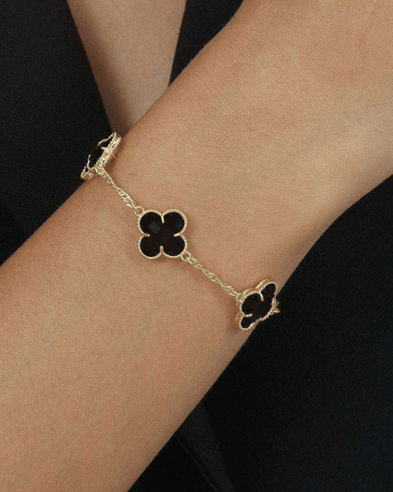 Pulseira Dourada Trevos com Zircônia Preta Auvane sendo usada — visual real