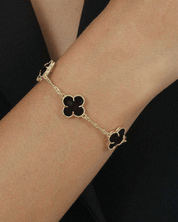 Pulseira Dourada Trevos com Zircônia Preta Auvane sendo usada — visual real