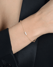 Pulseira Dourada de Pérolas com Ponto de Luz Auvane sendo usada — visual real
