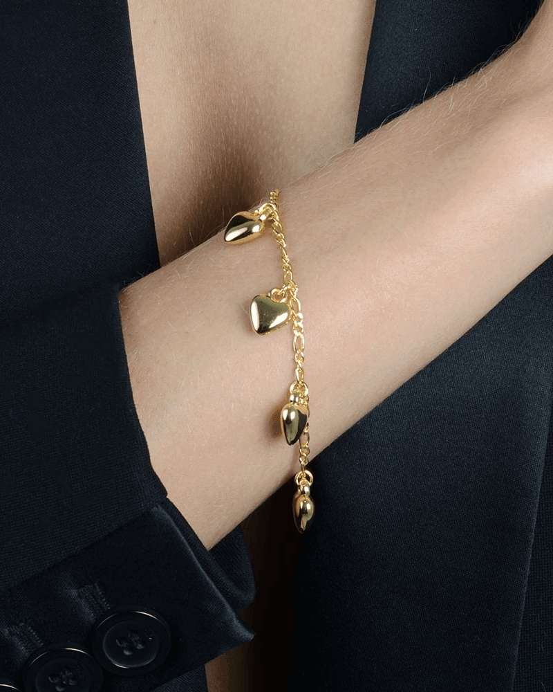 Pulseira Dourada com Pingentes de Coração Auvane sendo usada — visual real